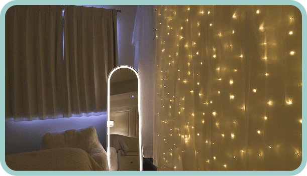 Cozy room with fairy lights and a standing mirror.