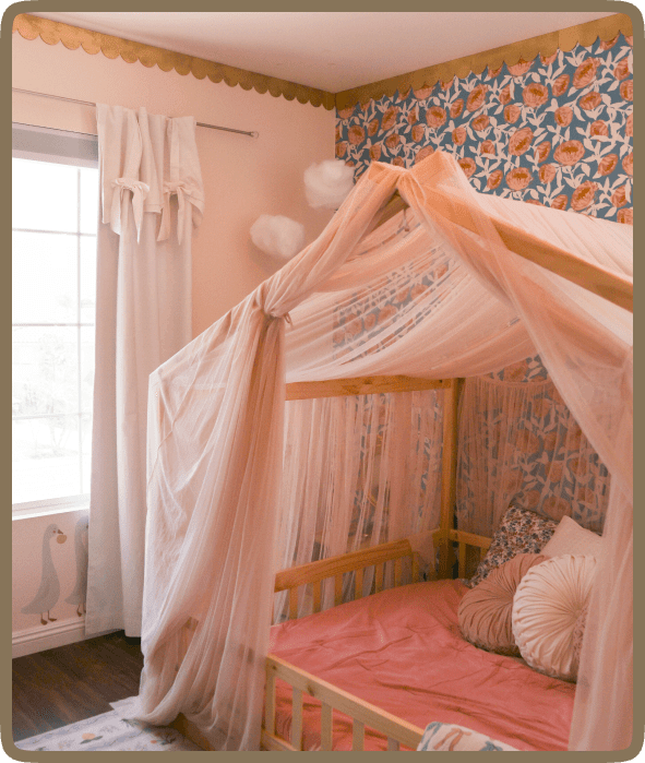 Cozy bedroom with a canopy bed draped in soft pink fabric.