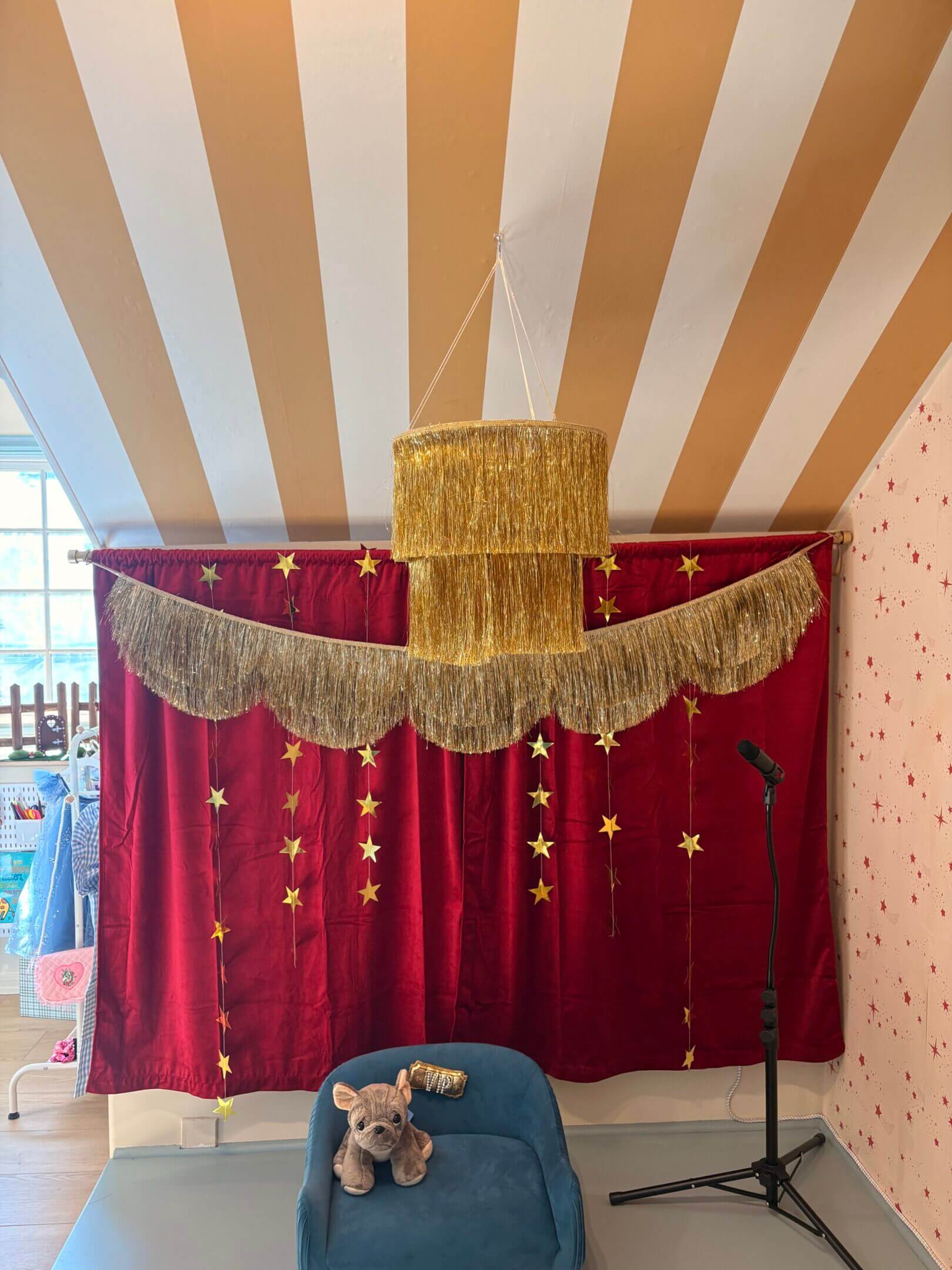 Decorated wedding stage with red and gold drapes and floral accents.